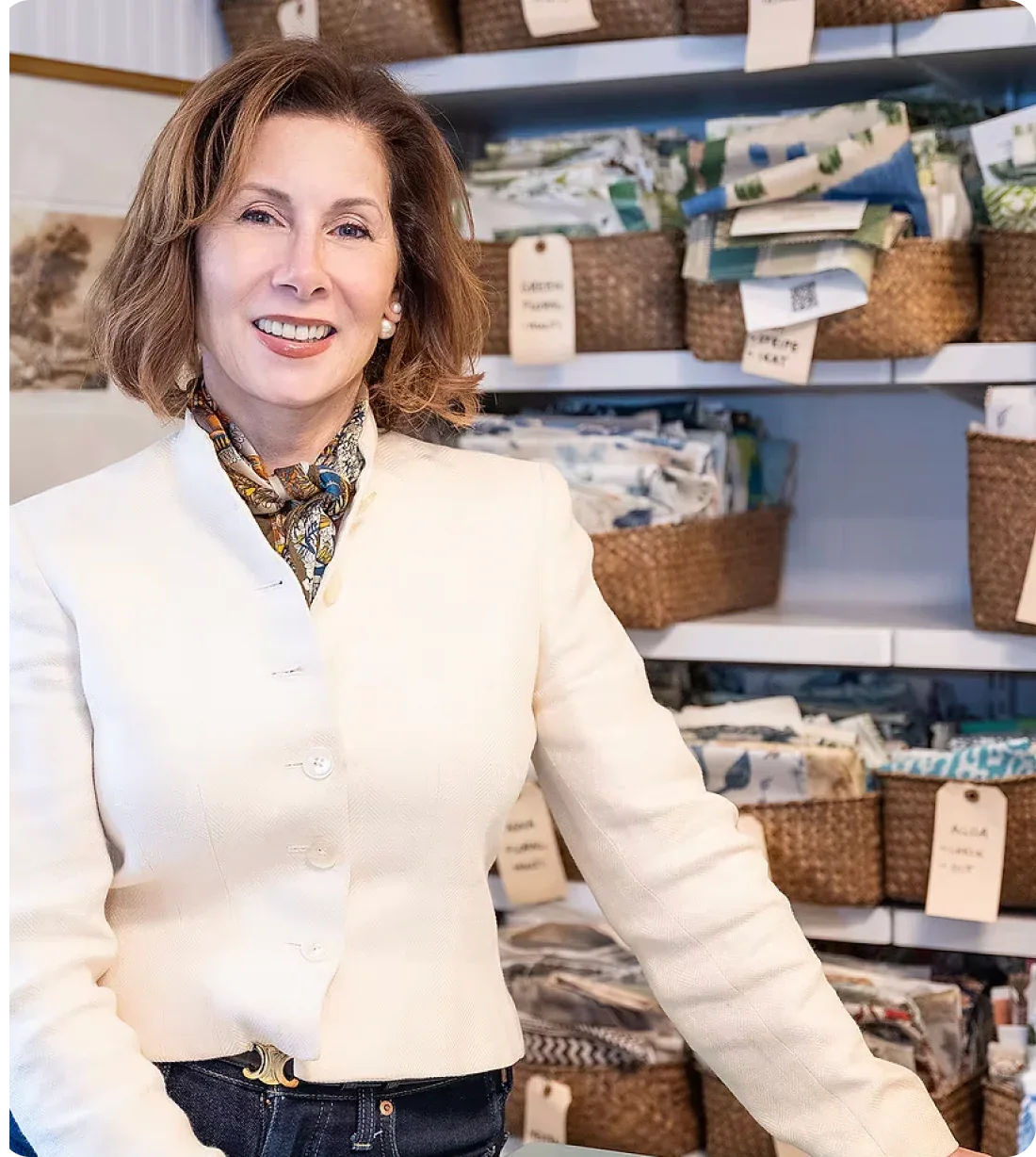 Woman in a white sweater standing in a store with shelves in the background